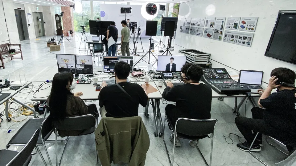 로비에 차린 중계석에서 스위처와 음향 콘솔로 강연을 송출하는 제작진